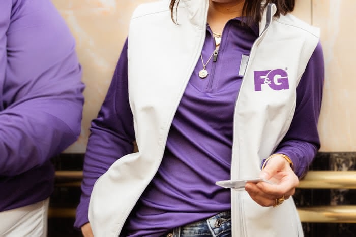 cropped image of someone wearing F&G longsleeve quarter-zip and cream vest over top