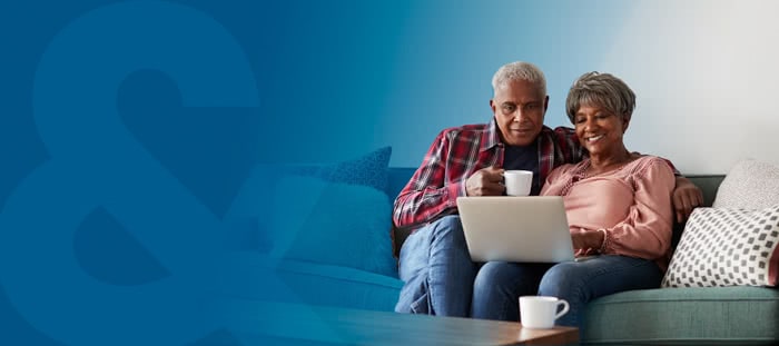 branded blue banner featuring an older couple sitting on a couch and using a laptop