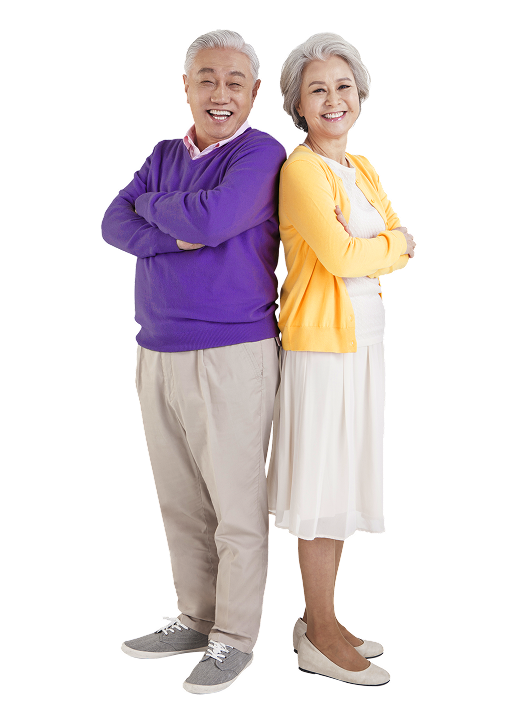 An older Asian couple stands back to back smiling